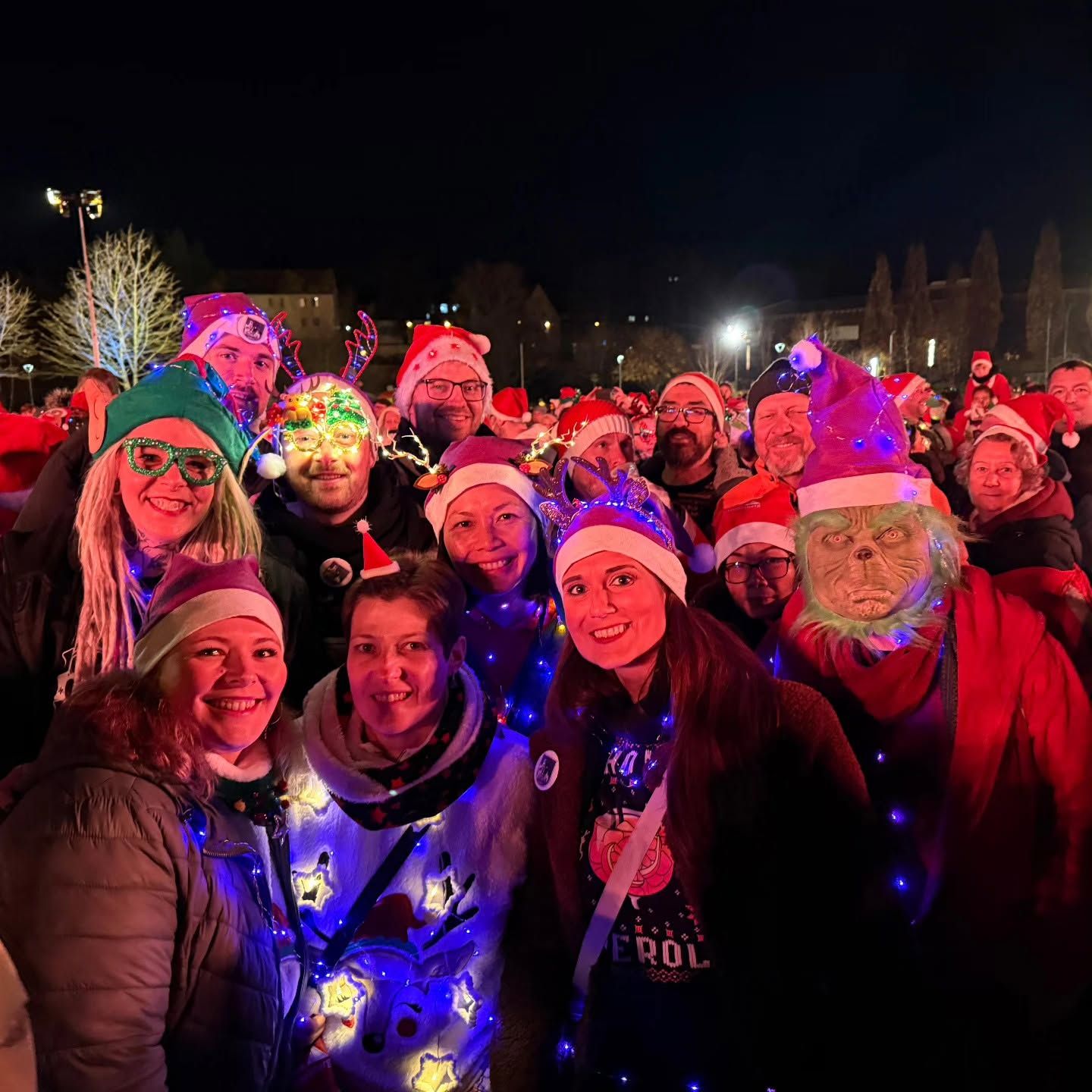 Mitglieder mit Weihnachtsmützen und Lichterketten beim Weltrekordversuch am Abend