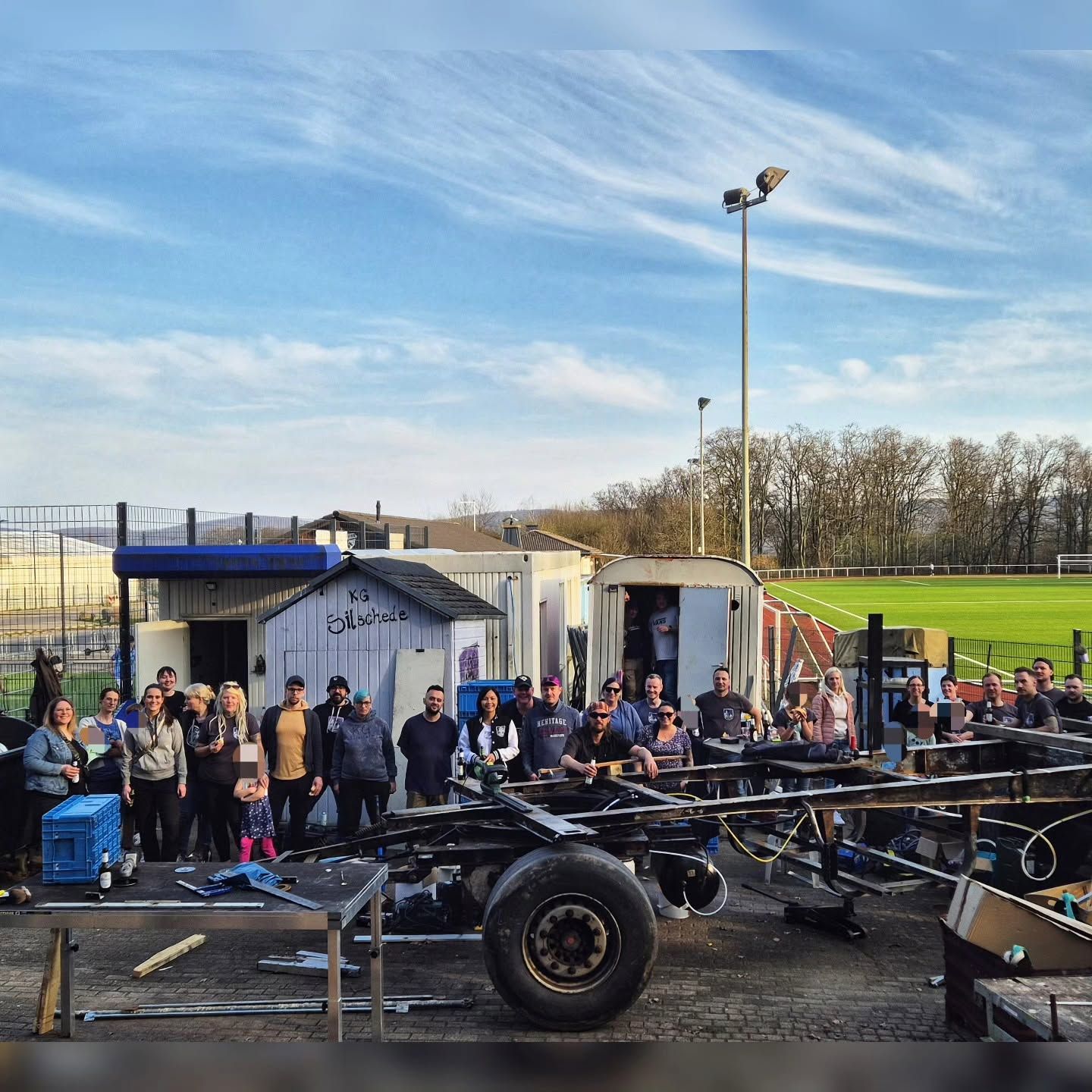 Mitglieder auf dem Bauplatz am Waldstadion vor dem leeren Fahrgestell